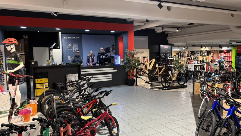 Das Sportmike-Team an der Kassa, davor Kinderräder und Rennräder im Verkaufsraum